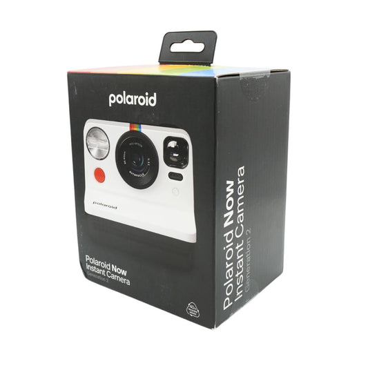 A black and white polaroid camera in a black box, titled the Polaroid Now