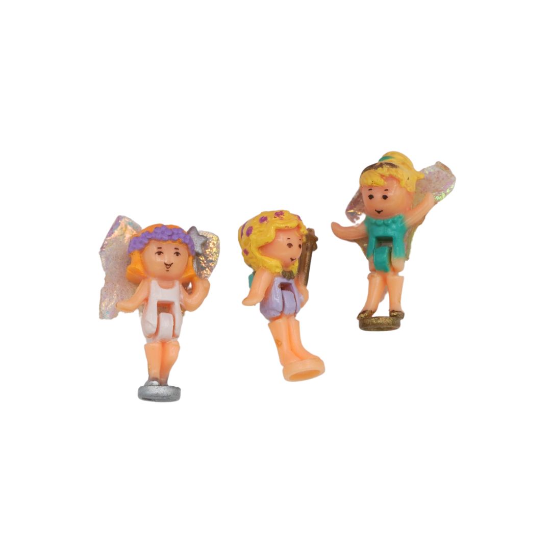 Three small fairy figurines with different hairstyles and outfits on a white background