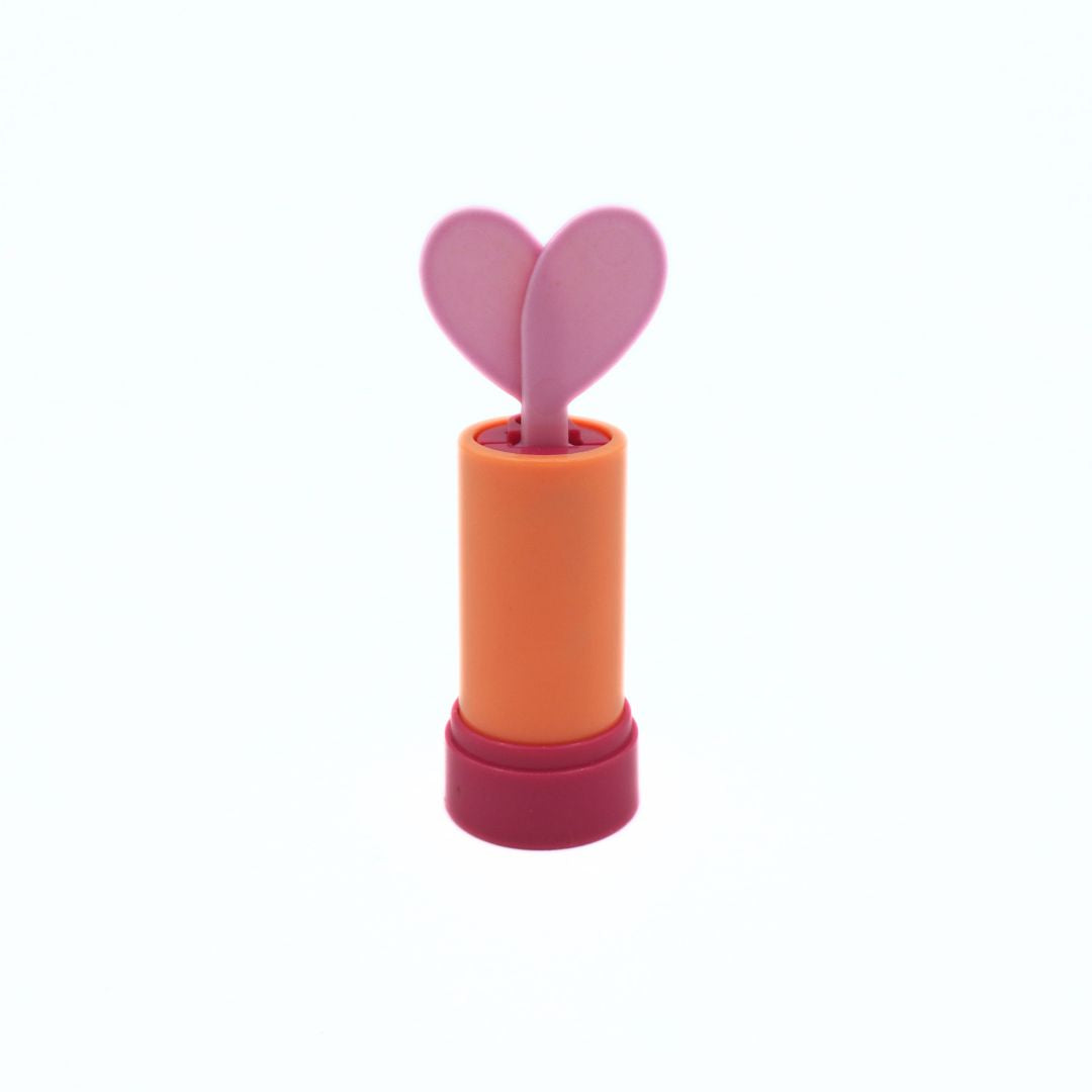 A small novelty lipstick-shaped object with a pink heart-shaped applicator or decorative top mounted on an orange cylindrical body and a dark pink base, shown on a plain white background.