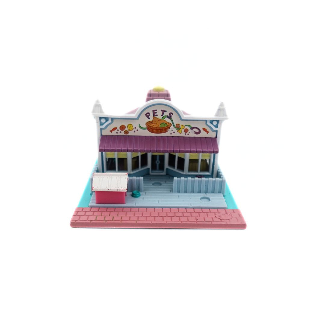 Front on image of the 1993 Bluebird Polly Pocket Pet Shop, with a pink, blue and purple colour palette.