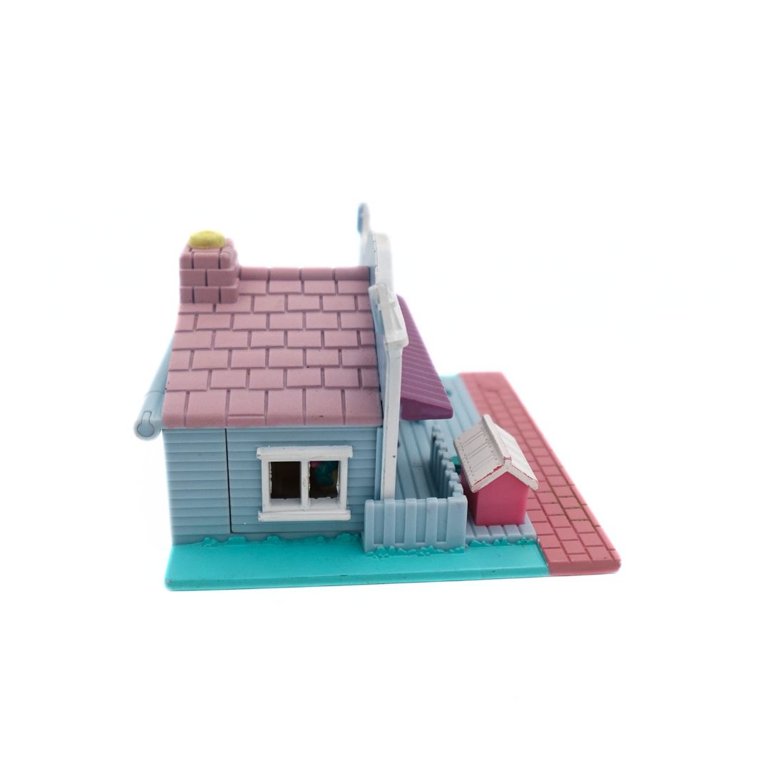 Side on image of the 1993 Bluebird Polly Pocket Pet Shop, with a pink, blue and purple colour palette.