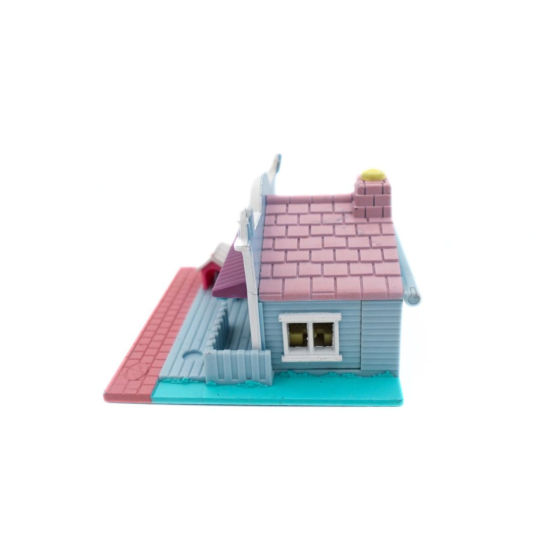 Side on image of the 1993 Bluebird Polly Pocket Pet Shop, with a pink, blue and purple colour palette.