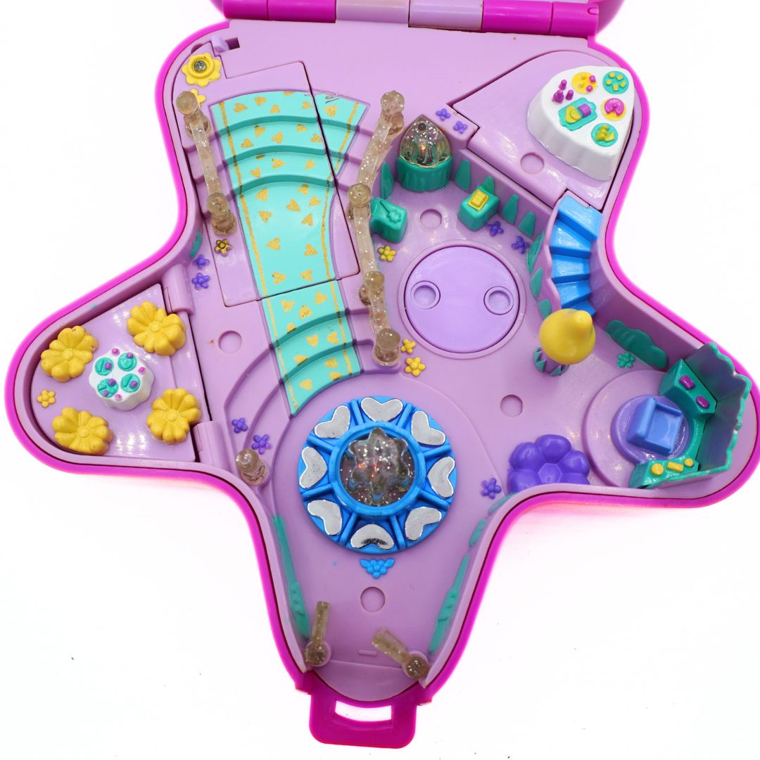 Toy Polly Pocket set with various compartments on a white background