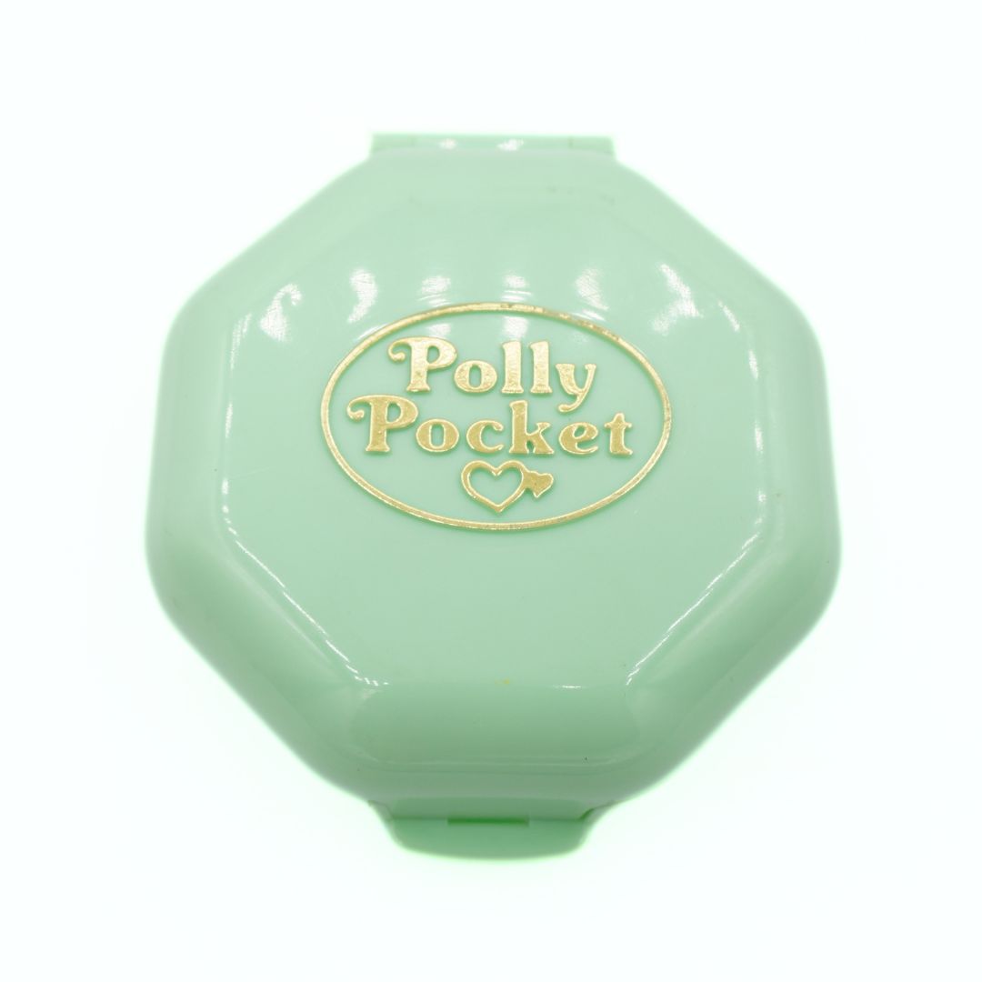 Green Polly Pocket toy container on a white background