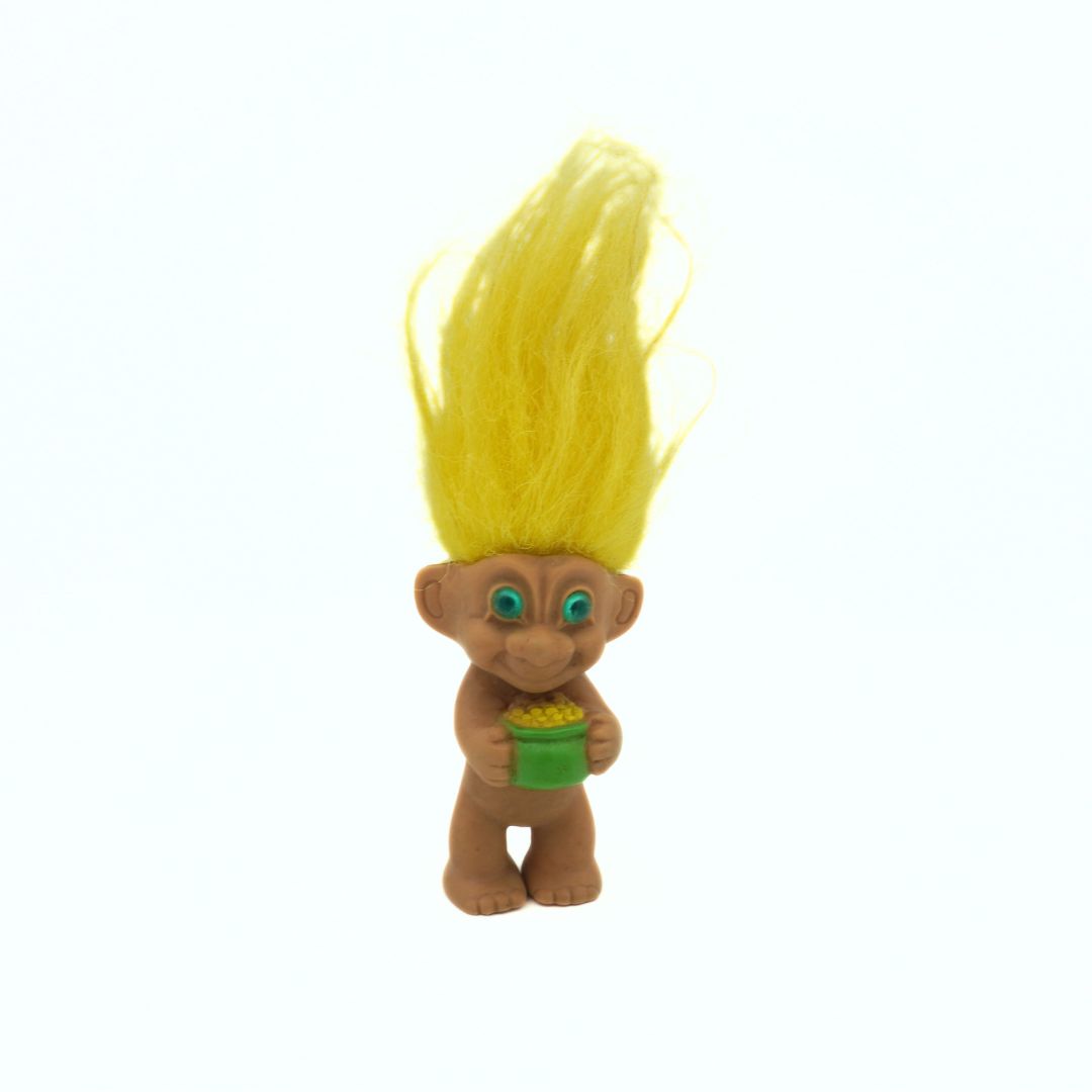 Toy figure with blonde hair and green outfit on a white background