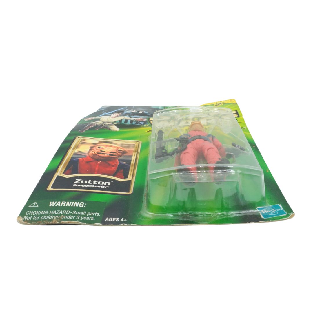 Toy figure in packaging with a card featuring 'Zutton' on a white background
