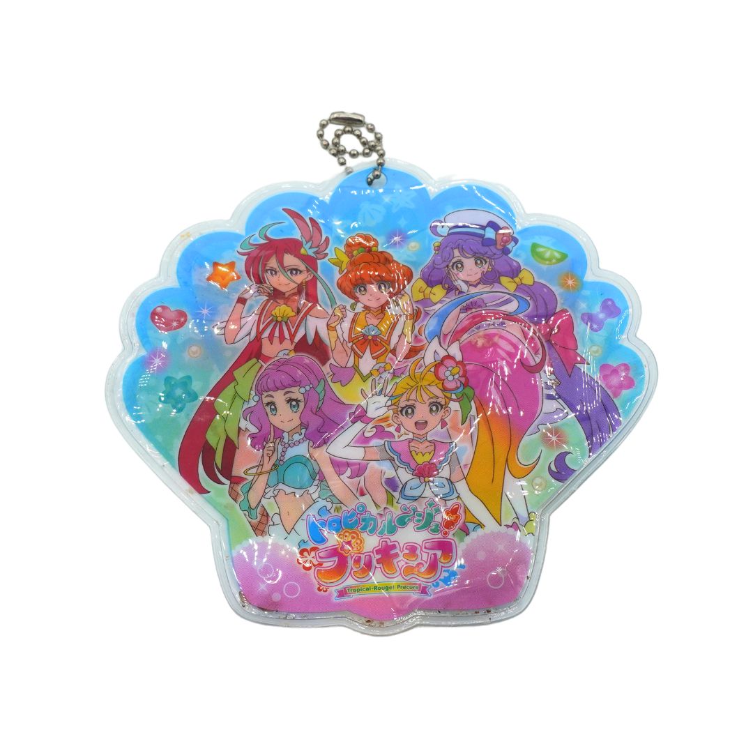 A colorful anime keychain charm in a scalloped shell shape, featuring multiple characters from Pretty Cure with glittery blue, pink, and purple details, attached to a silver ball chain on a white background.