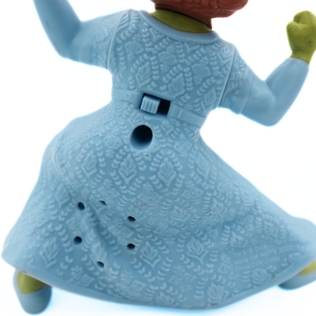 Closeup of the back of a 2007 McDonalds Princess Fiona Shrek toy showing the on/off switch and blue dress detailing