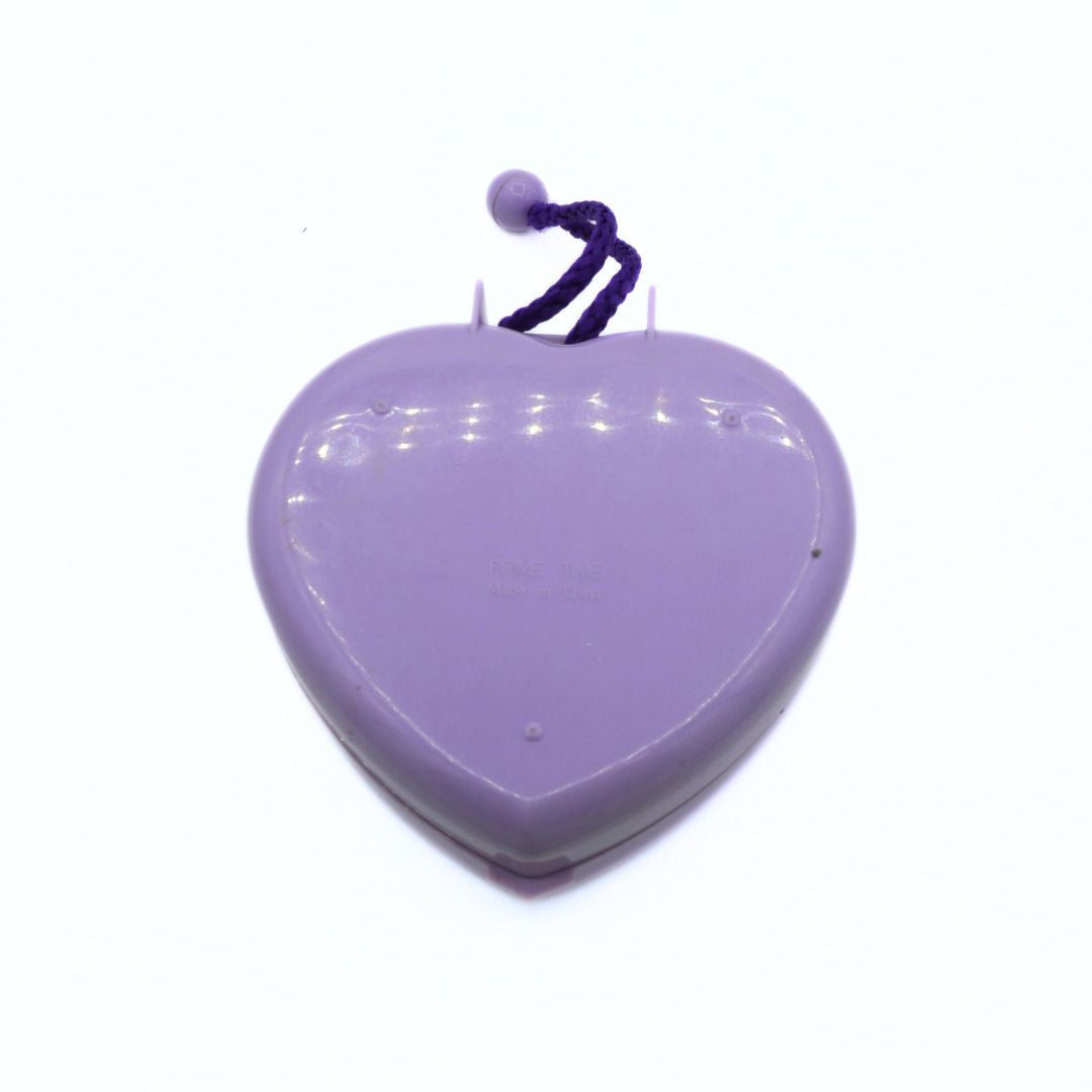 Purple heart-shaped object with a string on a white background