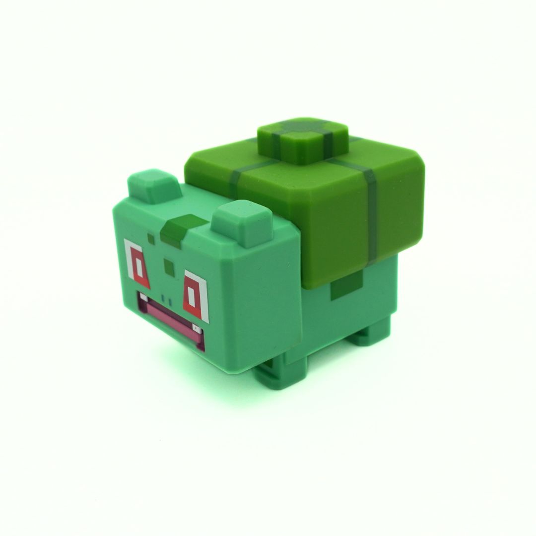 Green toy figure with blocky design on a white background
