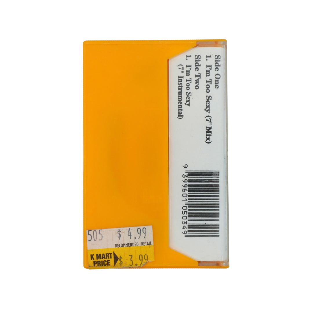 A cassette tape sleeve for K Mart's 'Too Sexy (Mix)' track, featuring a bright orange-yellow cover with a white barcode label and a K Mart price sticker.