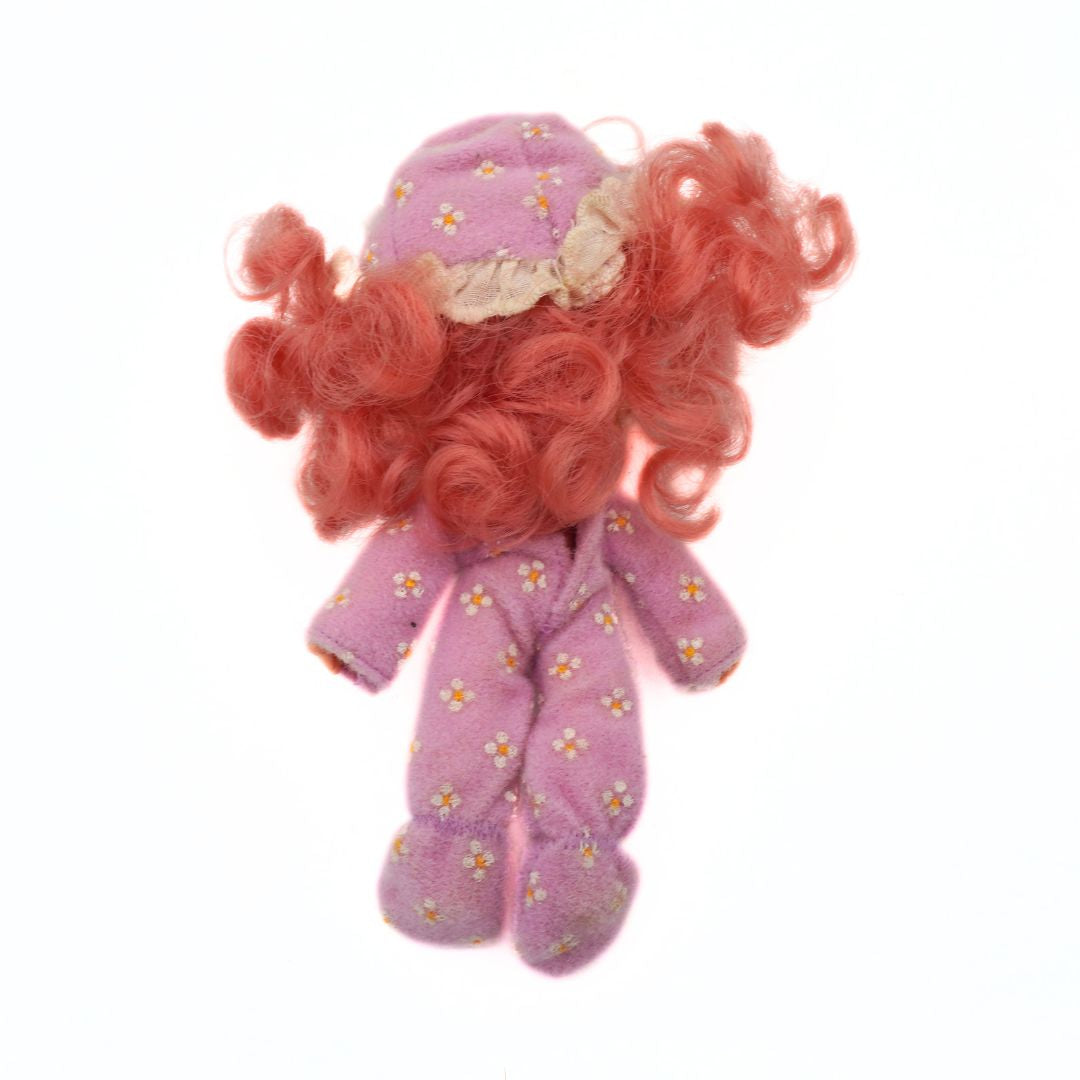 Plush toy with pink hair and outfit on a white background