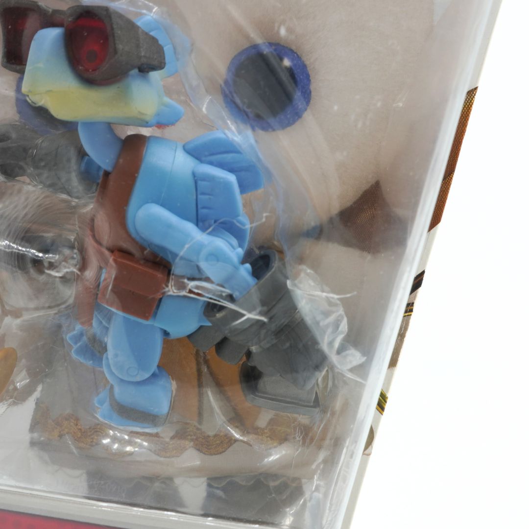 Toy figure in blue and brown colors with clear plastic packaging.