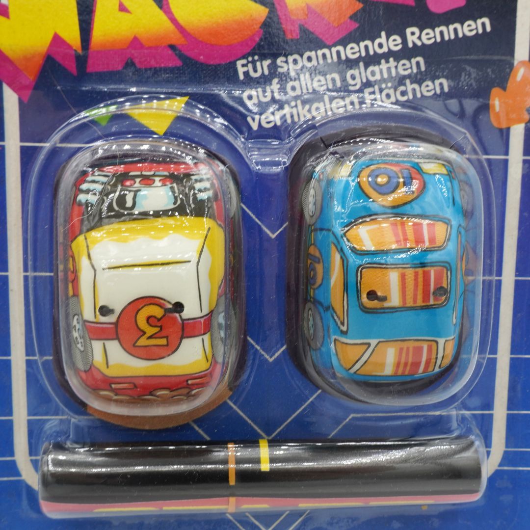 Two toy cars in packaging with German text on a blue background