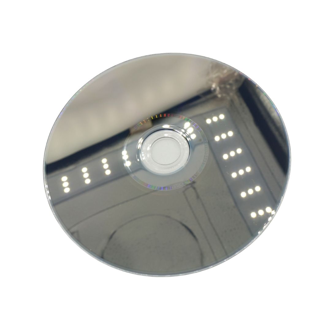 A reflective silver mirror disc with a small clear circular center, shown against a plain white background.