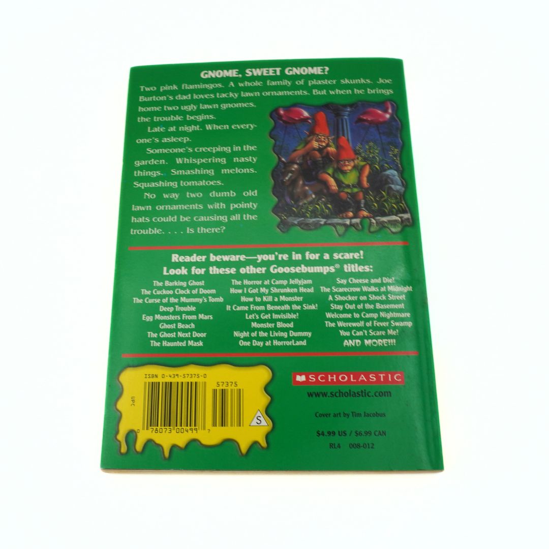 Back cover of a book with green background and text, featuring a barcode and Scholastic logo.