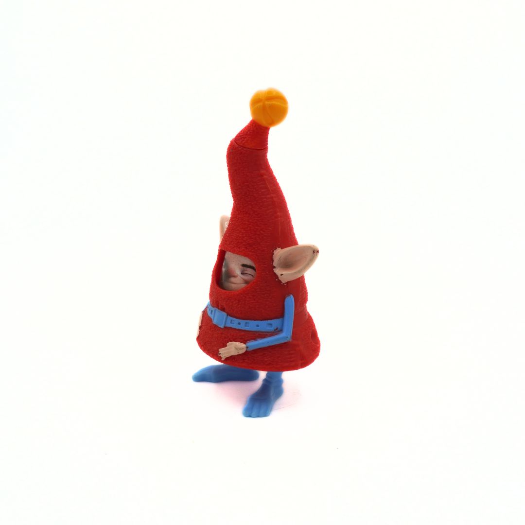 Small gnome figurine with a red hat and blue clothing on a white background