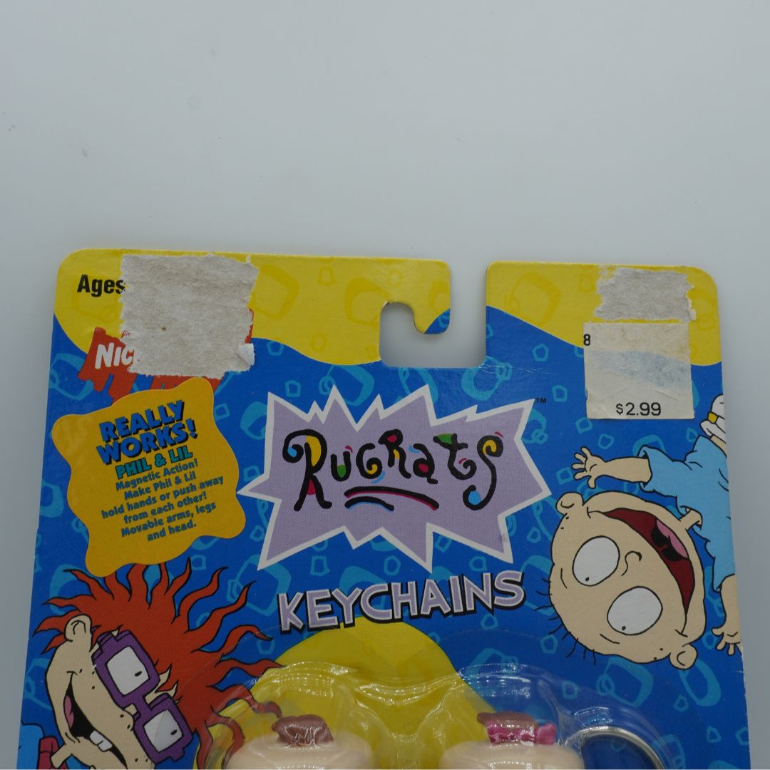 Packaged Rugrats keychains with cartoon characters on a blue and yellow background