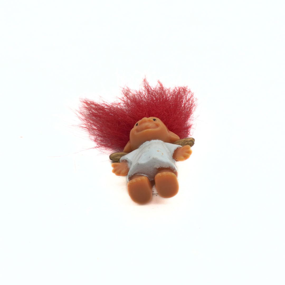 Russ Troll toy with red hair on a white background