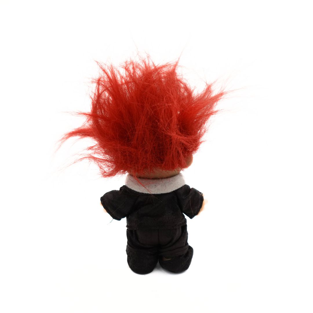 A photo of back of the 90s Russ Troll Doll Pilot in a dark brown outfit with orange hair