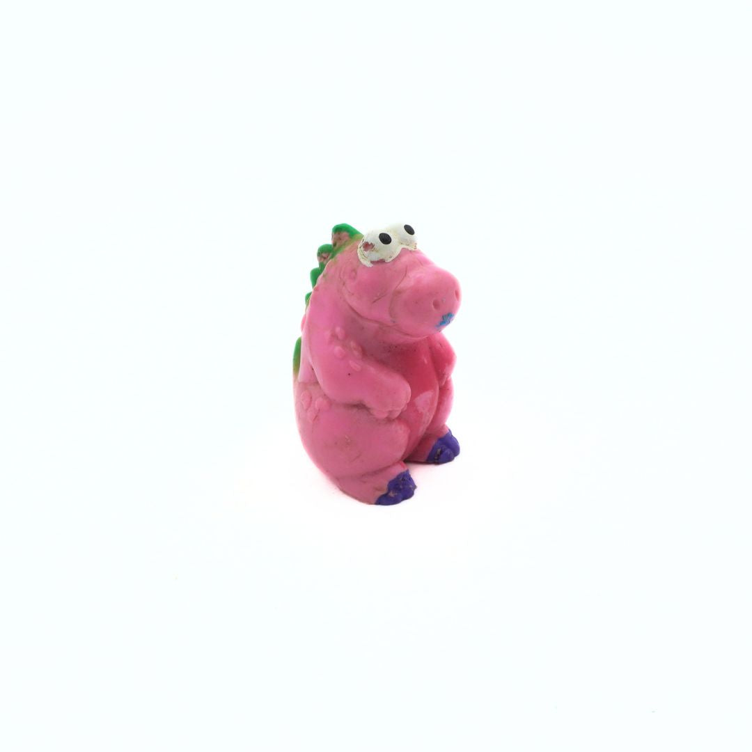 Pink plastic toy with green accents on a white background