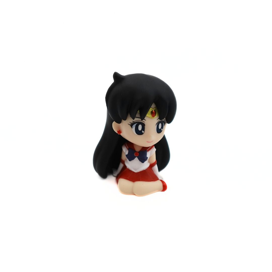 A small figurine of Sailor Mars sitting down and smiling in her red and purple uniform