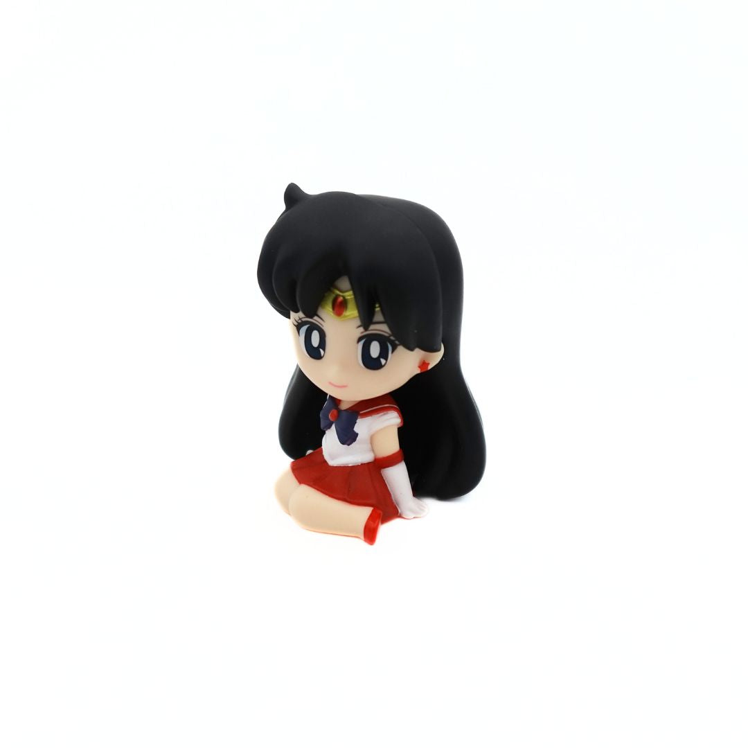 A small figurine of Sailor Mars sitting down and smiling in her red and purple uniform