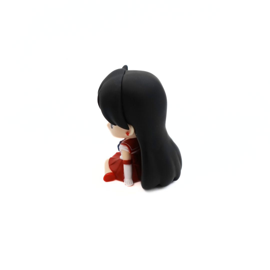 Side on photo of a small Sailor Mars figurine sitting and relaxing