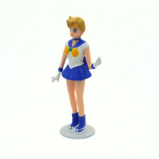 Action figure in a blue and white outfit with a yellow heart emblem on a white background