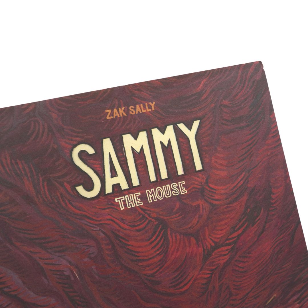 A close-up of a book cover titled 'SAMMY THE HOUSE' by Zak Sally, featuring cream-colored text over a dark red and black marbled patterned background.