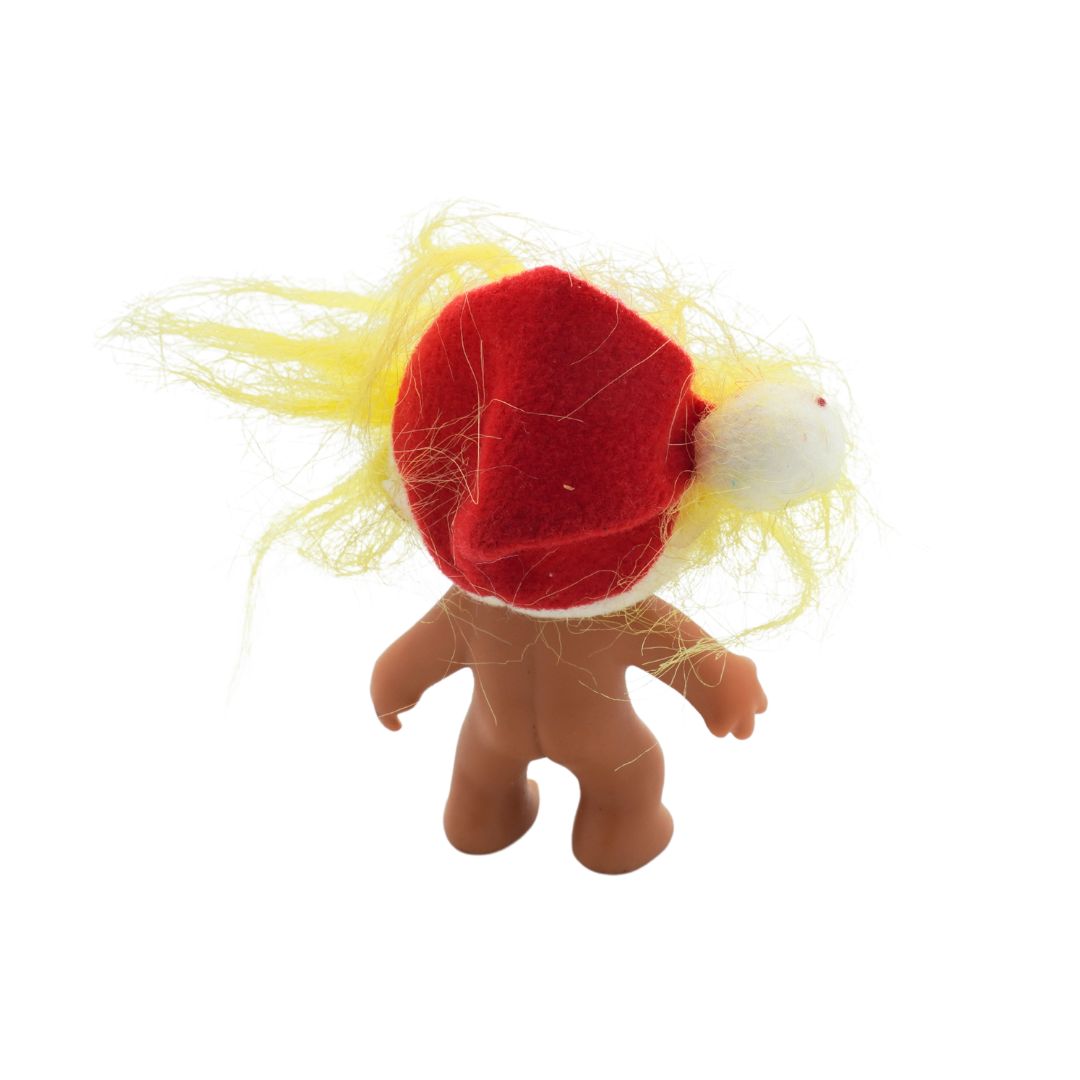 Small figurine with a red hat and yellow hair on a white background
