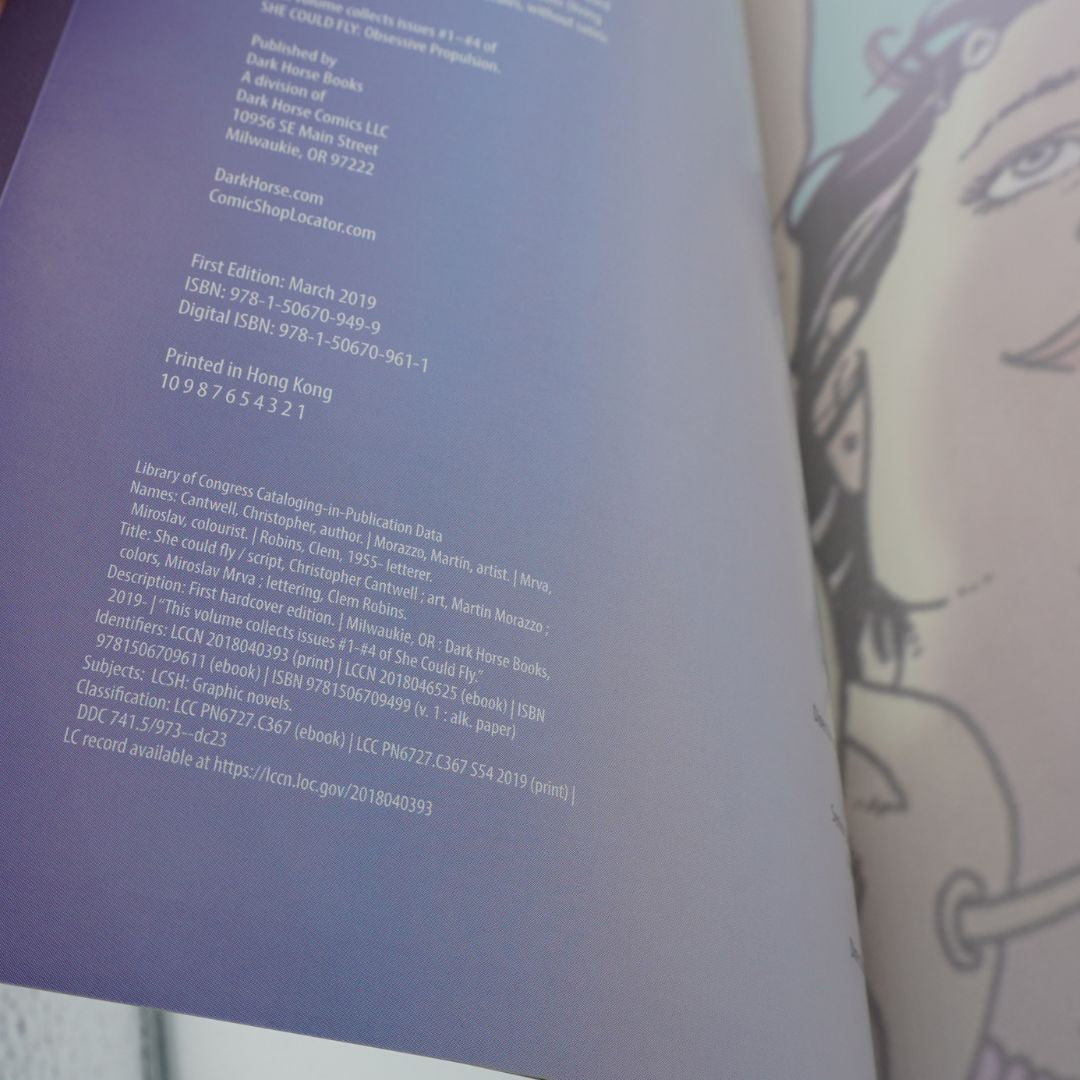 An open book showing printed text on the left page and a black-and-white illustrated character on the right page.