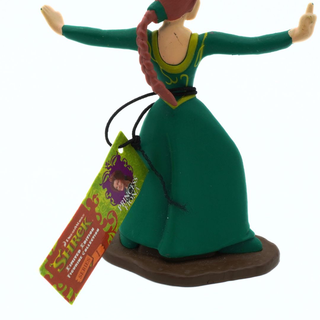 Figurine of a character in a green dress with a tag attached, on a white background