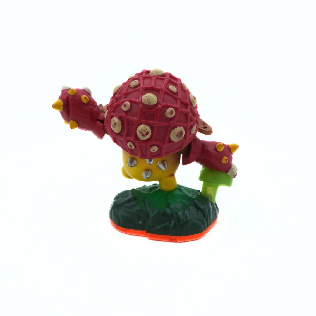 Colorful toy figure of a character with a red shell and green base on a white background