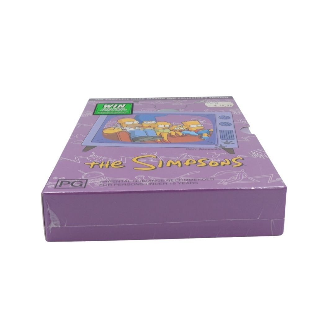 The Simpsons DVD box featuring a purple cover with the Simpson family illustration and the title 'The Simpsons' in yellow.