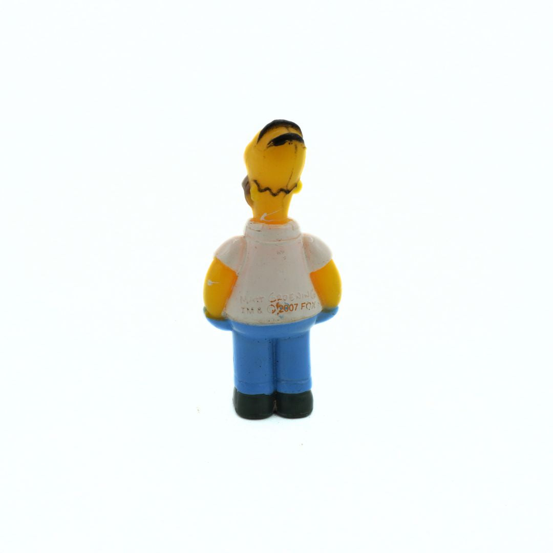 Simpsons figurine of a character with a white shirt and blue pants on a white background