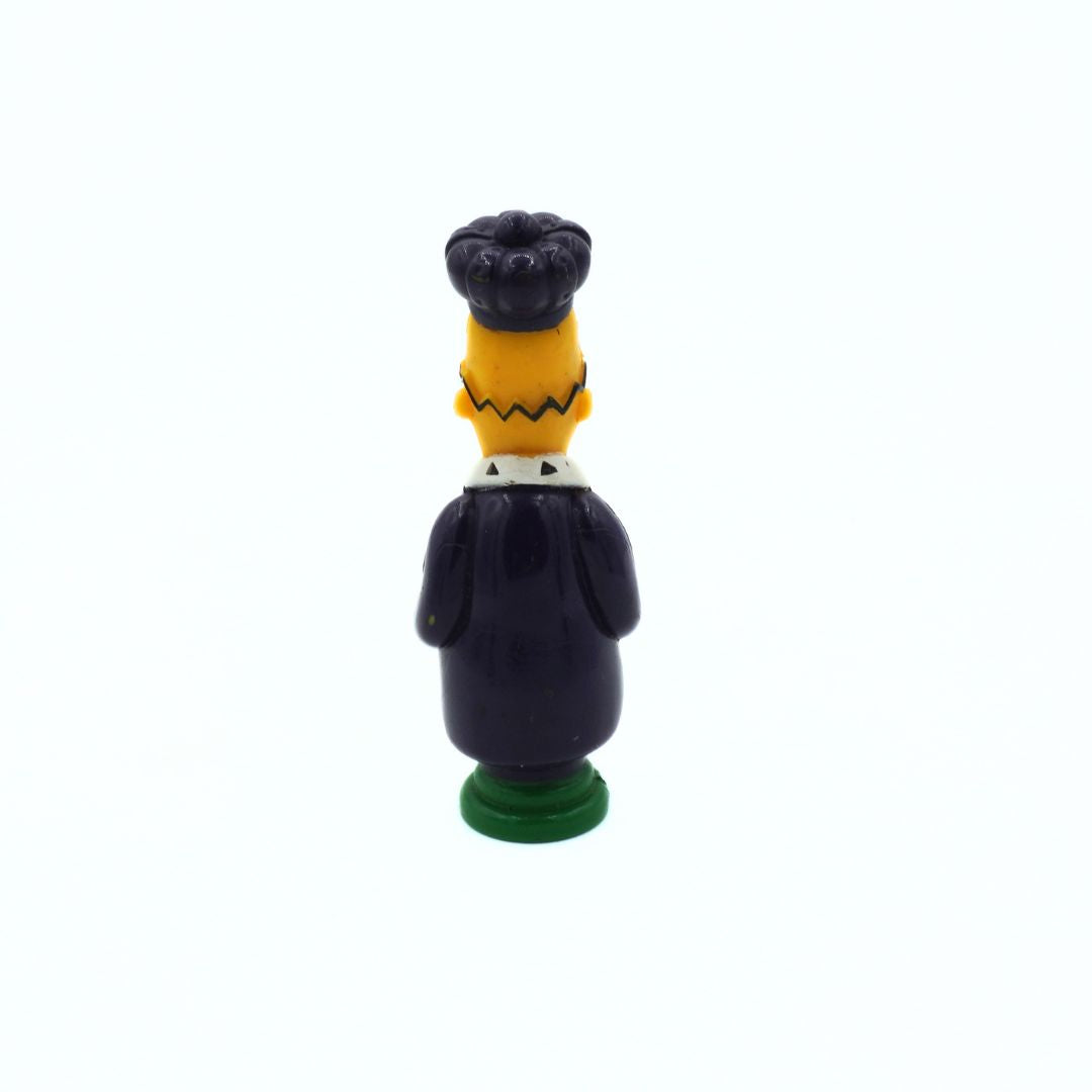 Small figurine of a character with a black hat and suit on a white background
