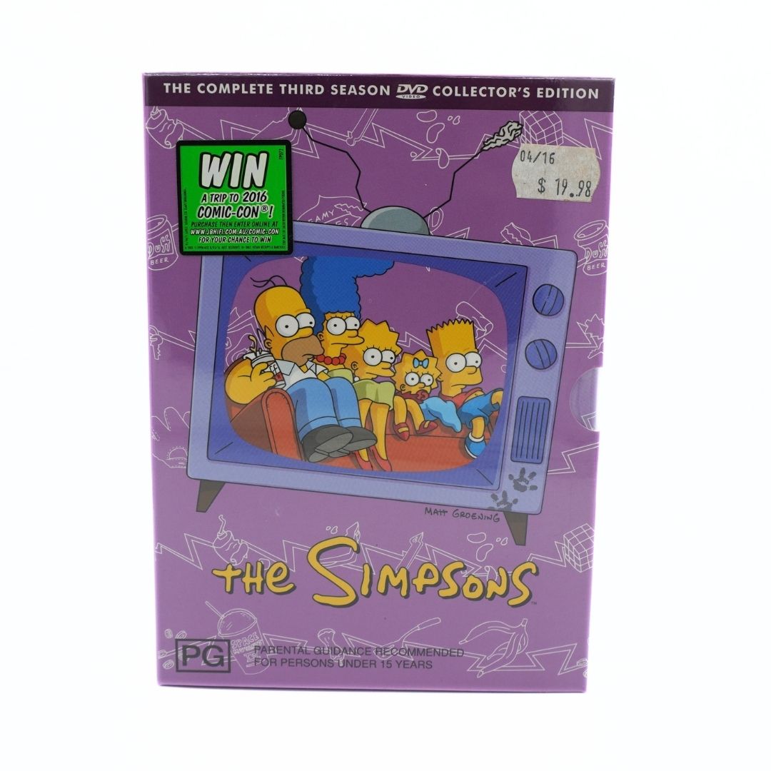 The Simpsons Complete Third Season DVD Collector's Edition box set, featuring a purple cover with an illustration of the family watching TV and a green 'Win at Your Own Risk' sticker.