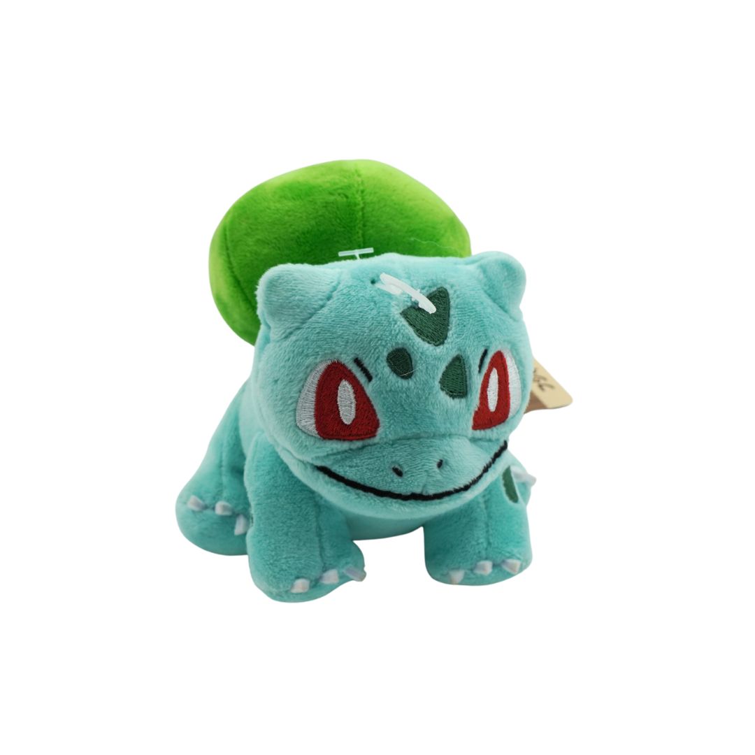 Plush toy of a green and blue creature with red eyes on a white background