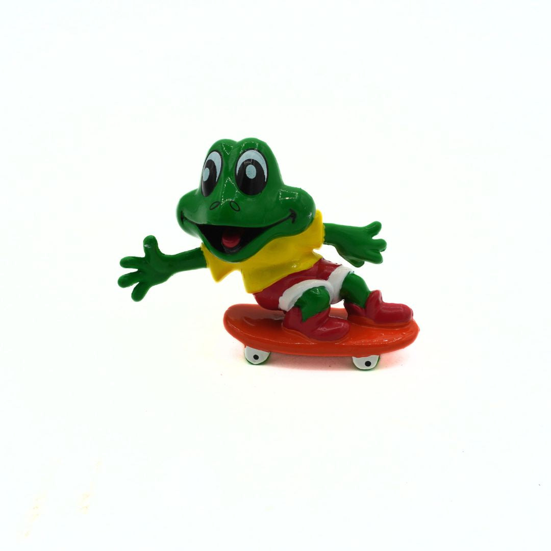Toy frog on a skateboard with a white background