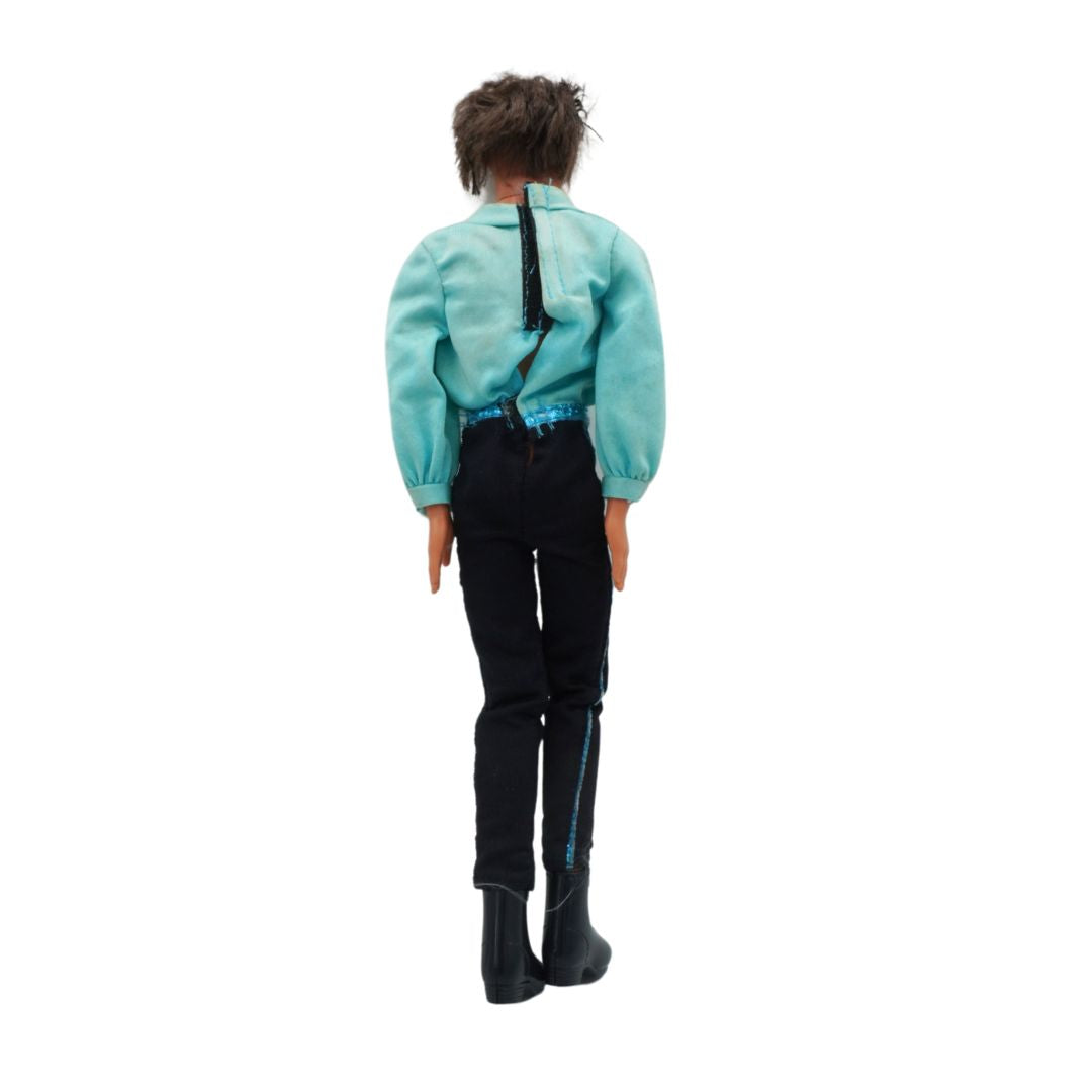 Ken doll in a green shirt and black pants with suspenders on a white background