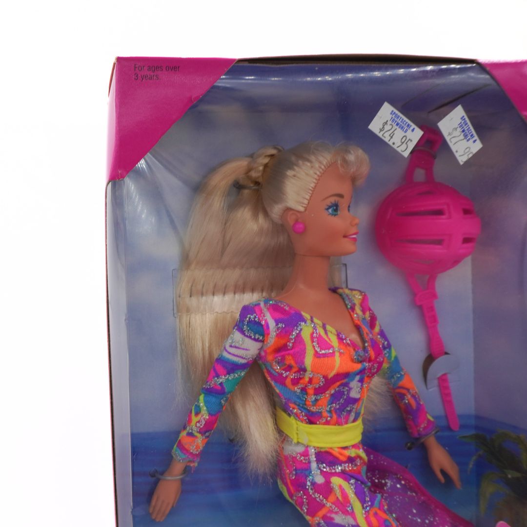 Barbie doll in colorful outfit with pink ball and toy in packaging
