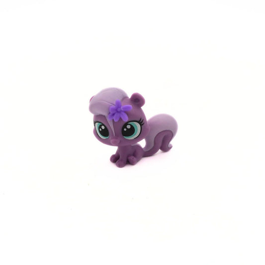 Purple toy skunk with a flower on a white background