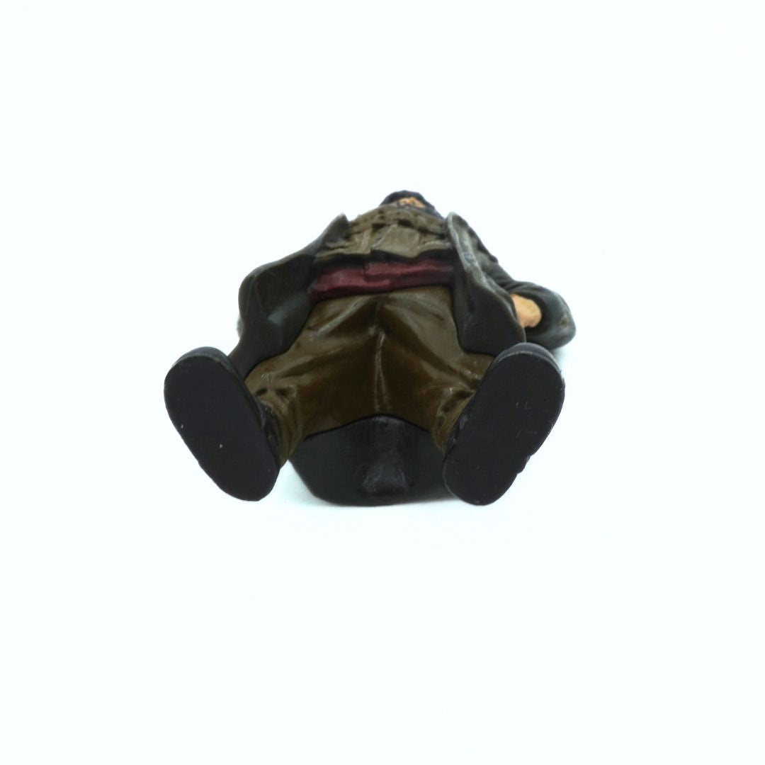 Small figurine of the underside of a Hagrid figurine on a white background
