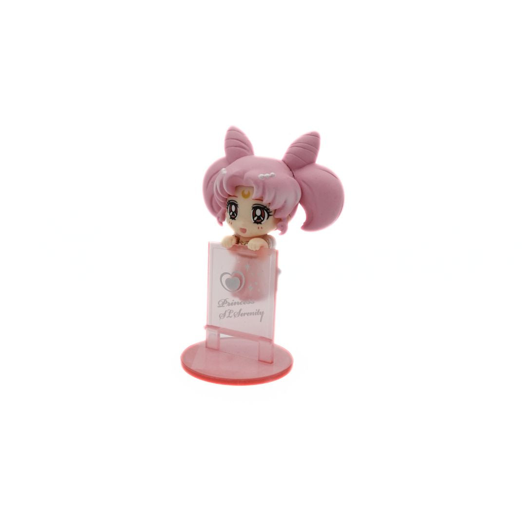 A photo of a mini figurine of the Sailor Moon Character Small Lady Serenity balancing on a translucent pink wall