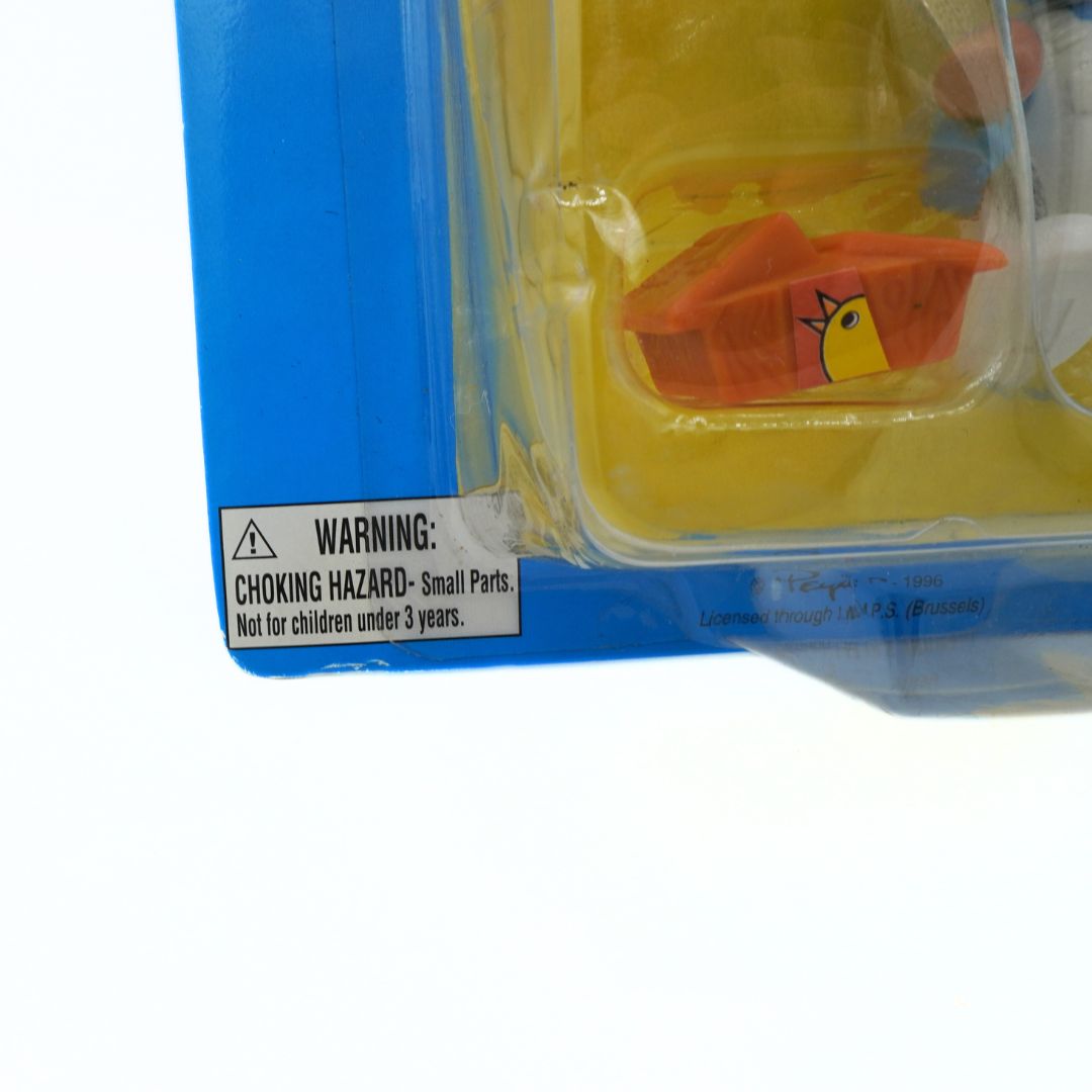 Toy figure in a clear plastic package with a warning label on a white background
