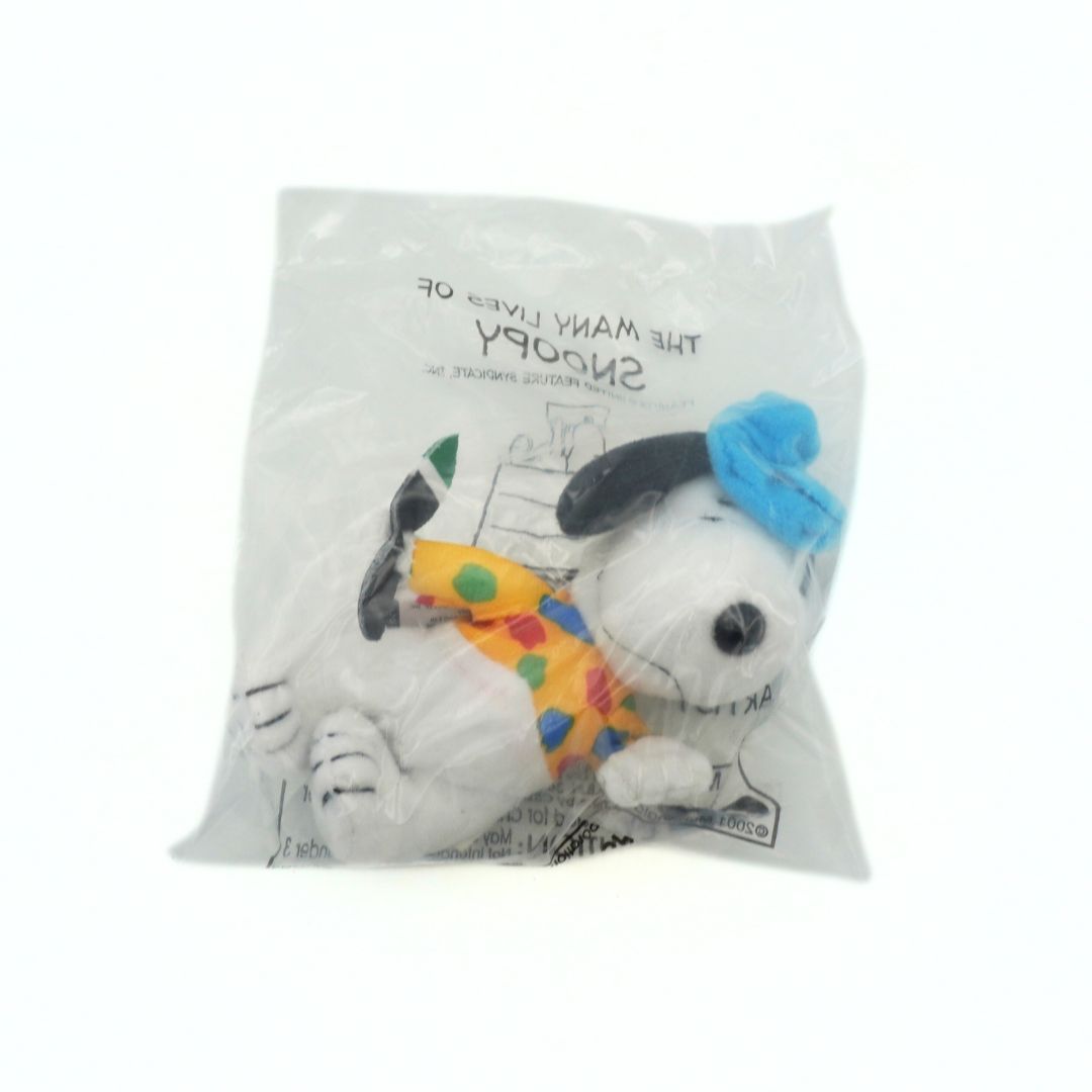 Plush toy resembling a dog with a colorful hat in a packaging sleeve with text.