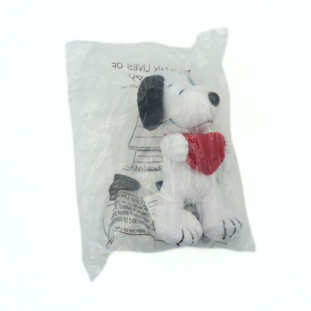 Plush dog toy with a red heart in packaging on a white background