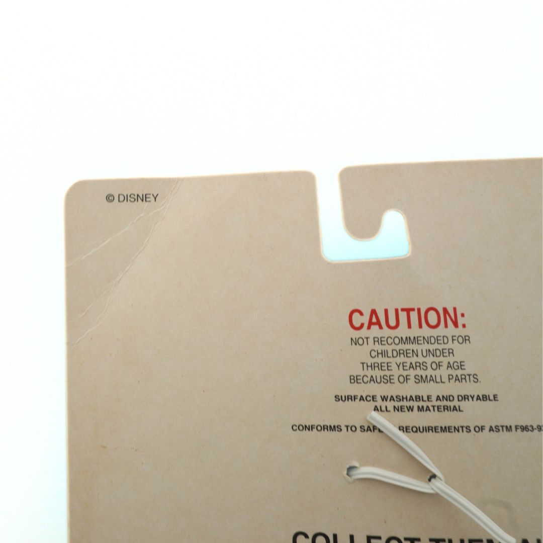 Cardboard backing with Disney branding and safety warning text on a white background