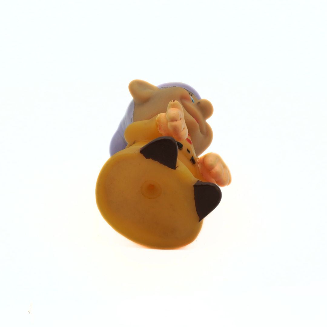 Toy figure of a character with a yellow hat and black shirt on a white background